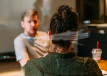 back of woman's head facing a man in a tshirt